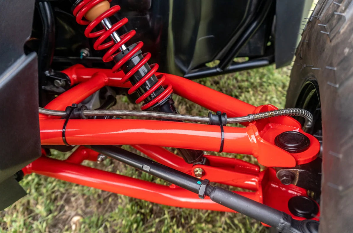 Zbliżenie czerwonych wahaczy przednich i amortyzatora w Polaris RZR200